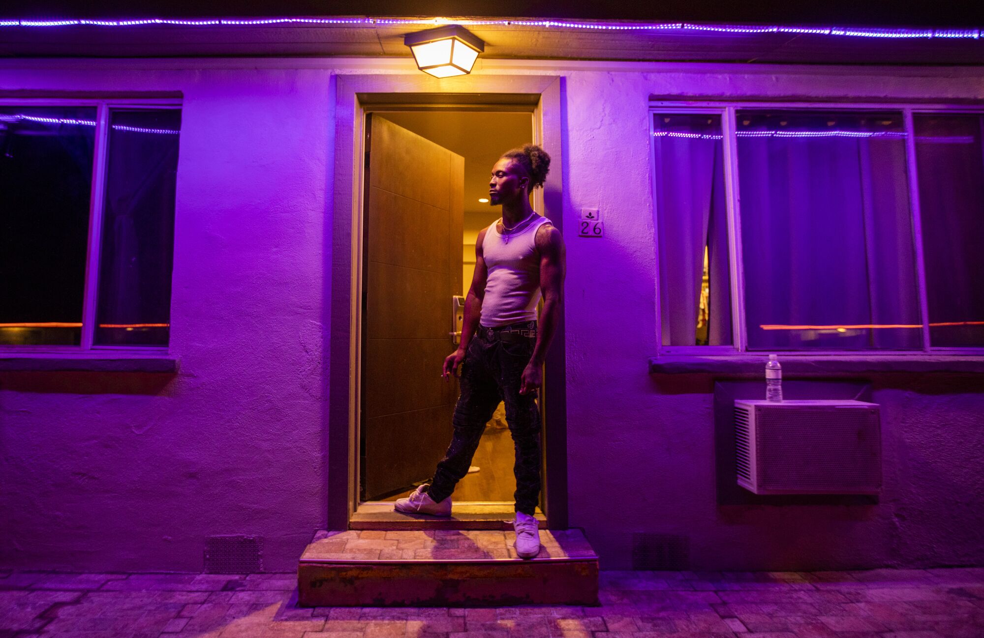 C'Tory Matthews smokes a cigarette as he stands in the door to his room at a motel.