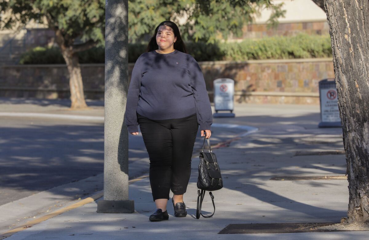 Portrait of Cal State San Marcos student Brittney Hansen walking on campus.