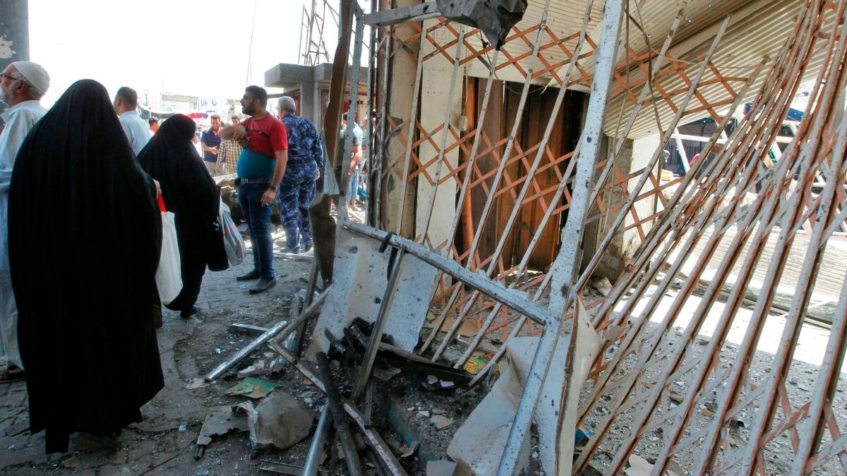 Iraqis gather at the site of a car bombing near Baghdad's Shuhada Bridge that killed at least five people and wounded 17 on May 30, 2017.