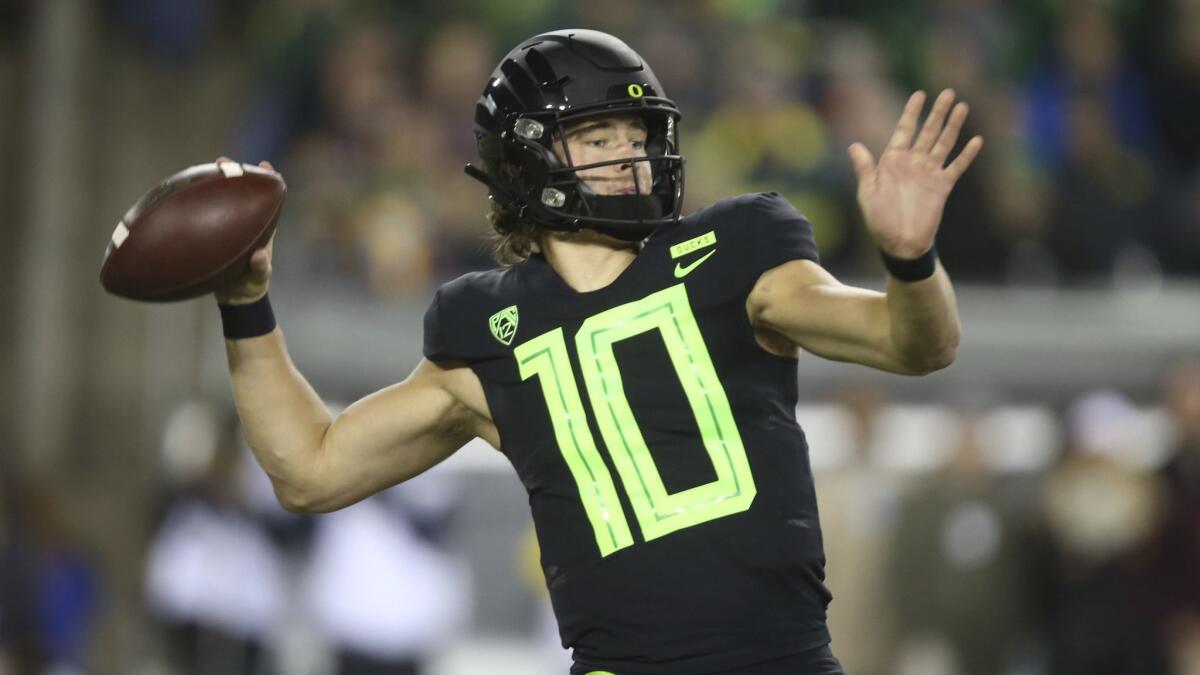 Justin Herbert of the Oregon Ducks looks to pass against the in