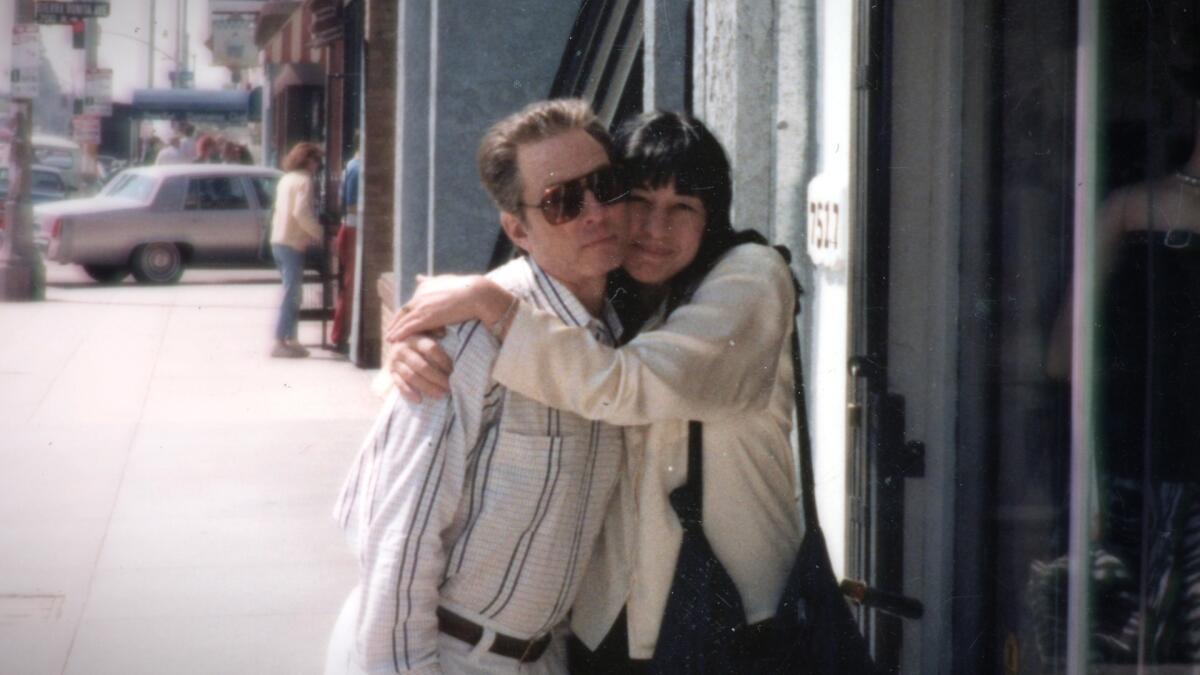 Robert Durst being hugged by Susan Berman on a sidewalk.