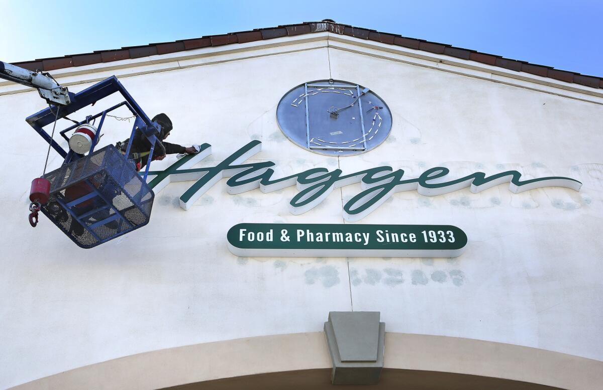 Supermarket chain Haggen auctioned off dozens of its stores Friday after trying -- and failing -- to expand this year. Above, a sign is installed at a Haggen store in Palmdale in March.