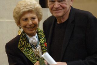 FILE - In this June 10, 2009, file photo, Czech-born author living in France Milan Kundera, right, is awarded the Simone and Cino Del Duca Foundation World Prize for his lifetime achievement in Paris, France. On the left is French political historian Helene Carrere d'Encausse. Kundera has regained Czech citizenship after 40 years, daily Pravo writes on Tuesday, Dec. 3, 2019, adding that Czech ambassador Petr Drulak handed the relevant document to him in his Paris apartment on November 28. (Remy Vlachos/CTK via AP)