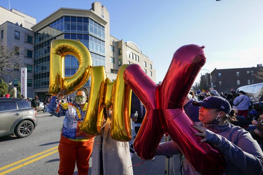 Fans hold up "DMX" balloons during a prayer vigil outside of White Plains Hospital, Monday, April 5, 2021, in White Plains, N.Y. Supporters and family of the rapper DMX have chanted his name and offered up prayers outside the hospital where he remains on life support. The 50-year-old was admitted to the hospital following a heart attack. (AP Photo/Mary Altaffer)
