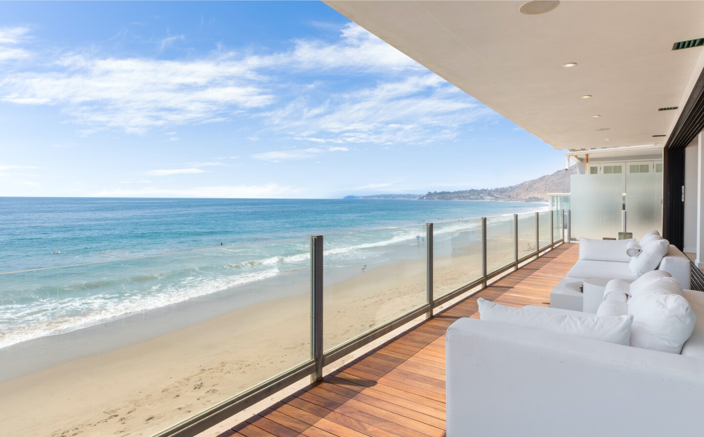 The architectural beach house expands to two levels of wood decks overlooking the ocean.