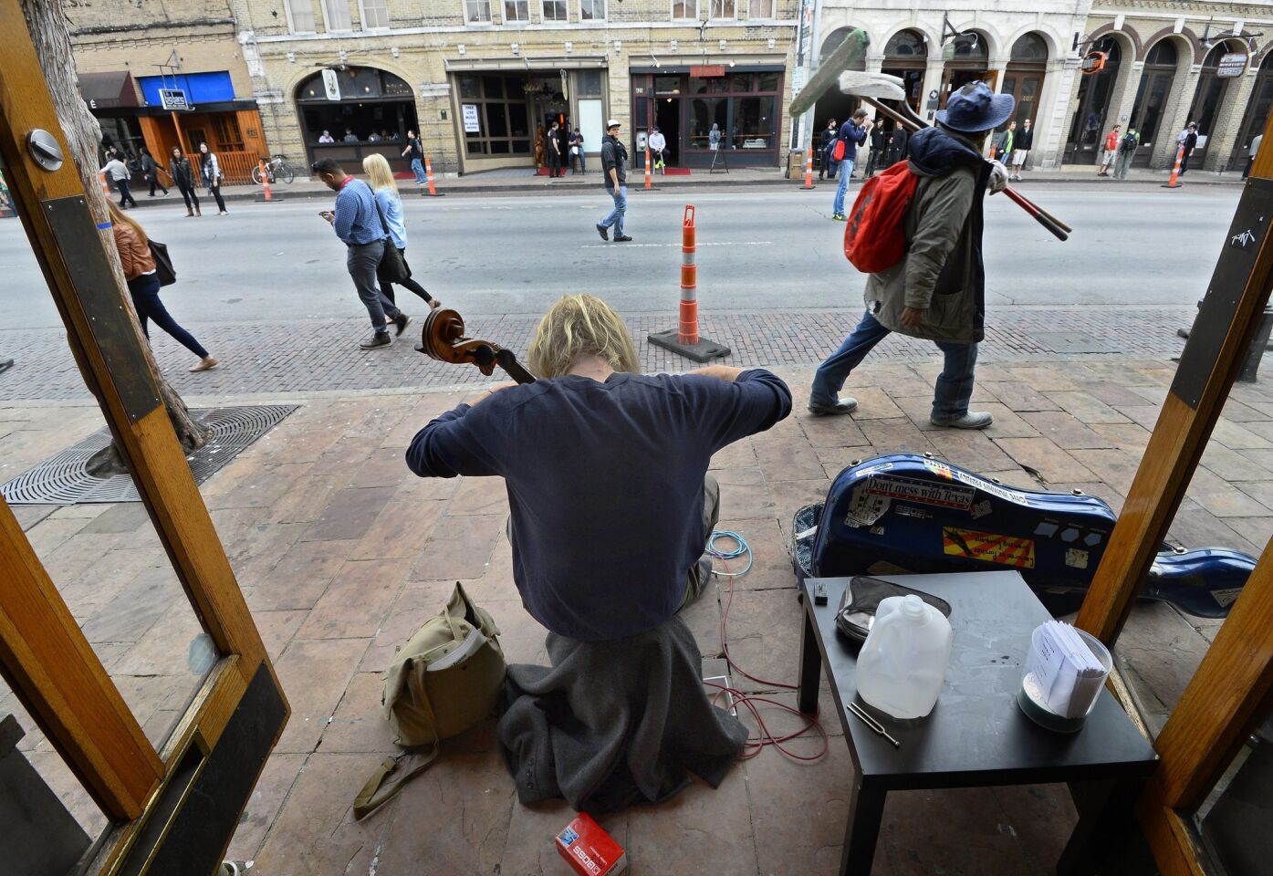 Martin Watkinson plays the cello on the sidewalk on the first official day of South by Southwest in Austin, Texas.