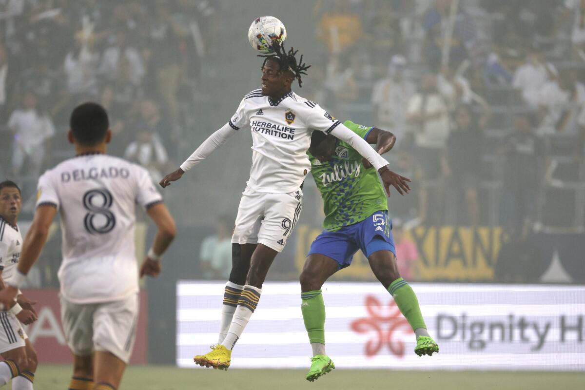 Galaxy forward Kévin Cabral heads the ball next to Seattle Sounders' Nouhou