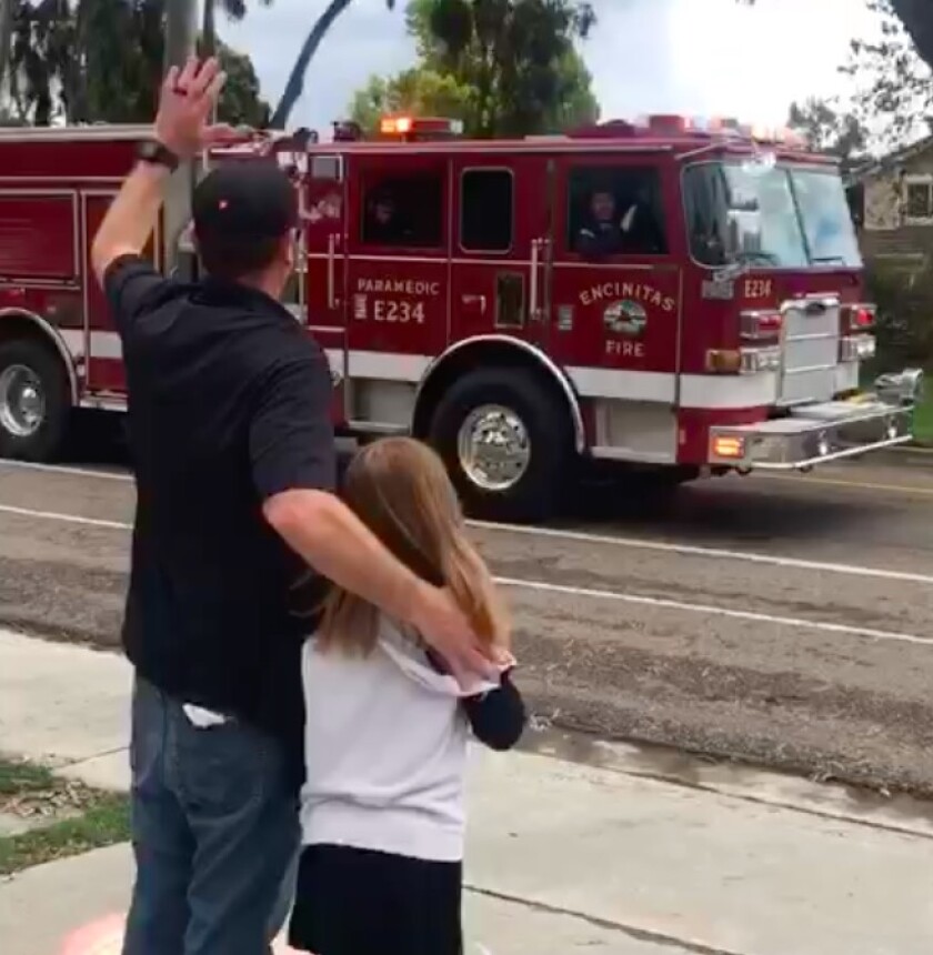 Rob and Maizy Tobin wave to Encinitas Fire truck who swung by the house for Maizy's birthday parade.