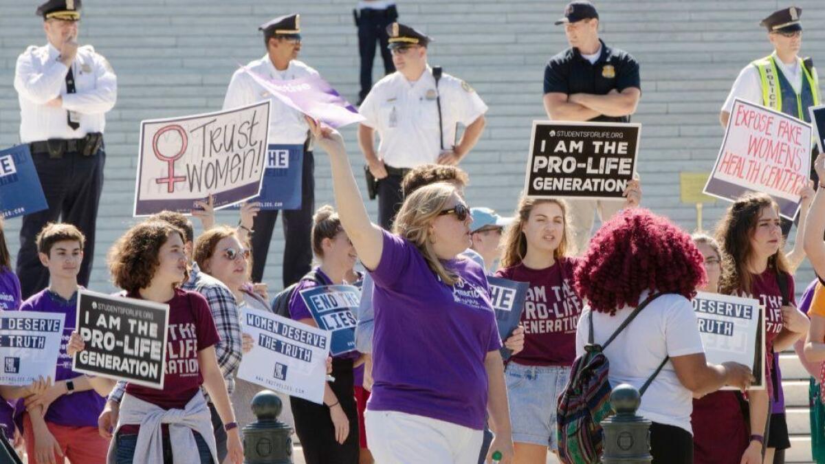 Abortion-rights and antiabortion advocates hold signs as they demonstrate in front of the Supreme Court in Washington on June 25, 2018.