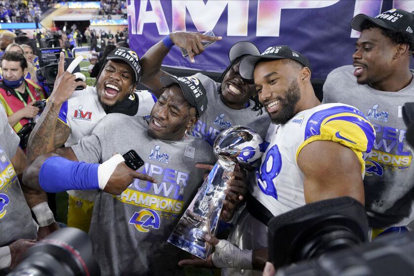 FILE - Los Angeles Rams players celebrate with the Lombardi Trophy after defeating the Cincinnati Bengals in the NFL Super Bowl 56 football game Sunday, Feb. 13, 2022, in Inglewood, Calif. The defending Super Bowl champion Los Angeles Rams host the Buffalo Bills in a battle of teams expected to challenge for the Lombardi Trophy to open the NFL season on Thursday night. (AP Photo/Mark J. Terrill, File