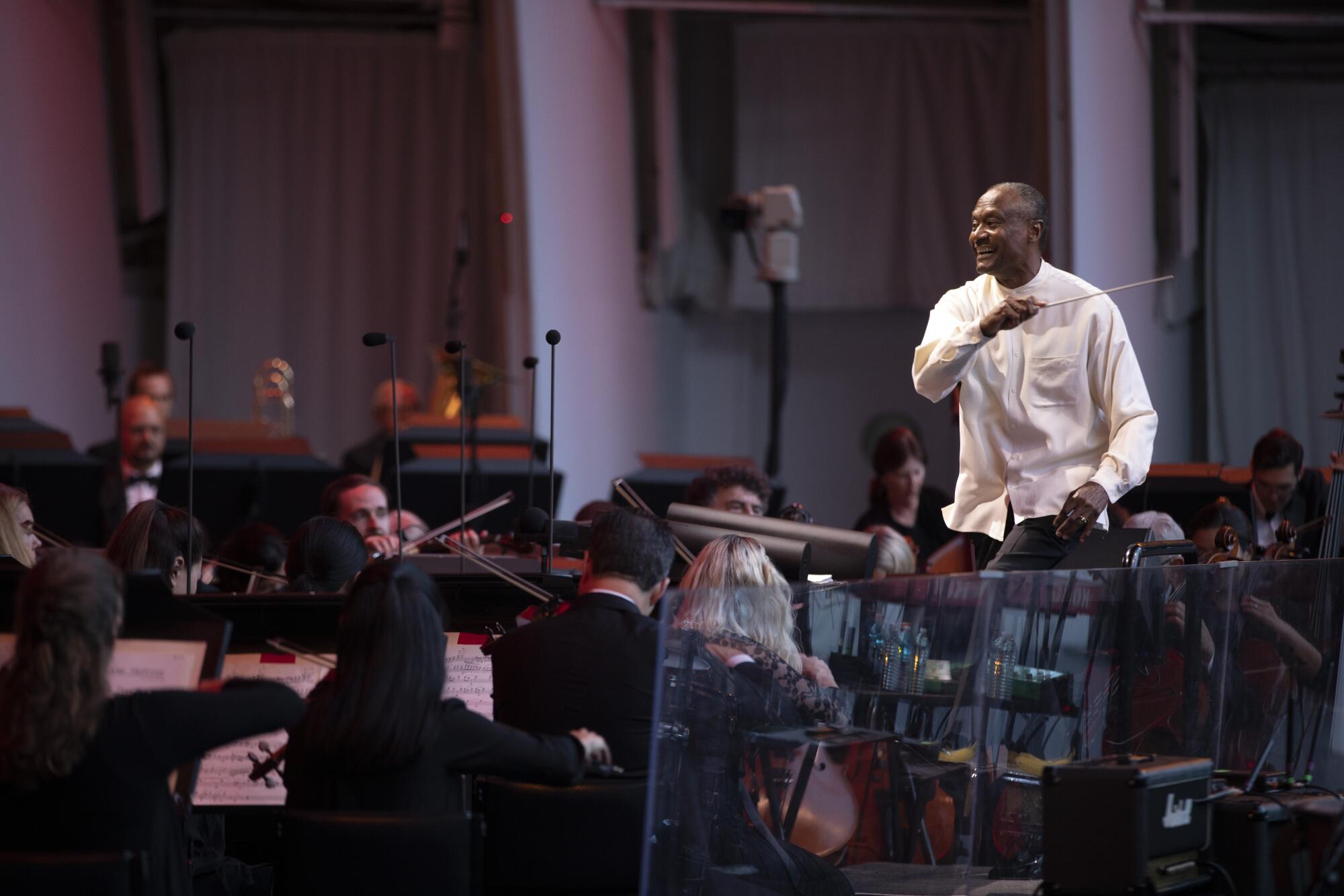 Thomas Wilkins waves the baton over orchestra players.