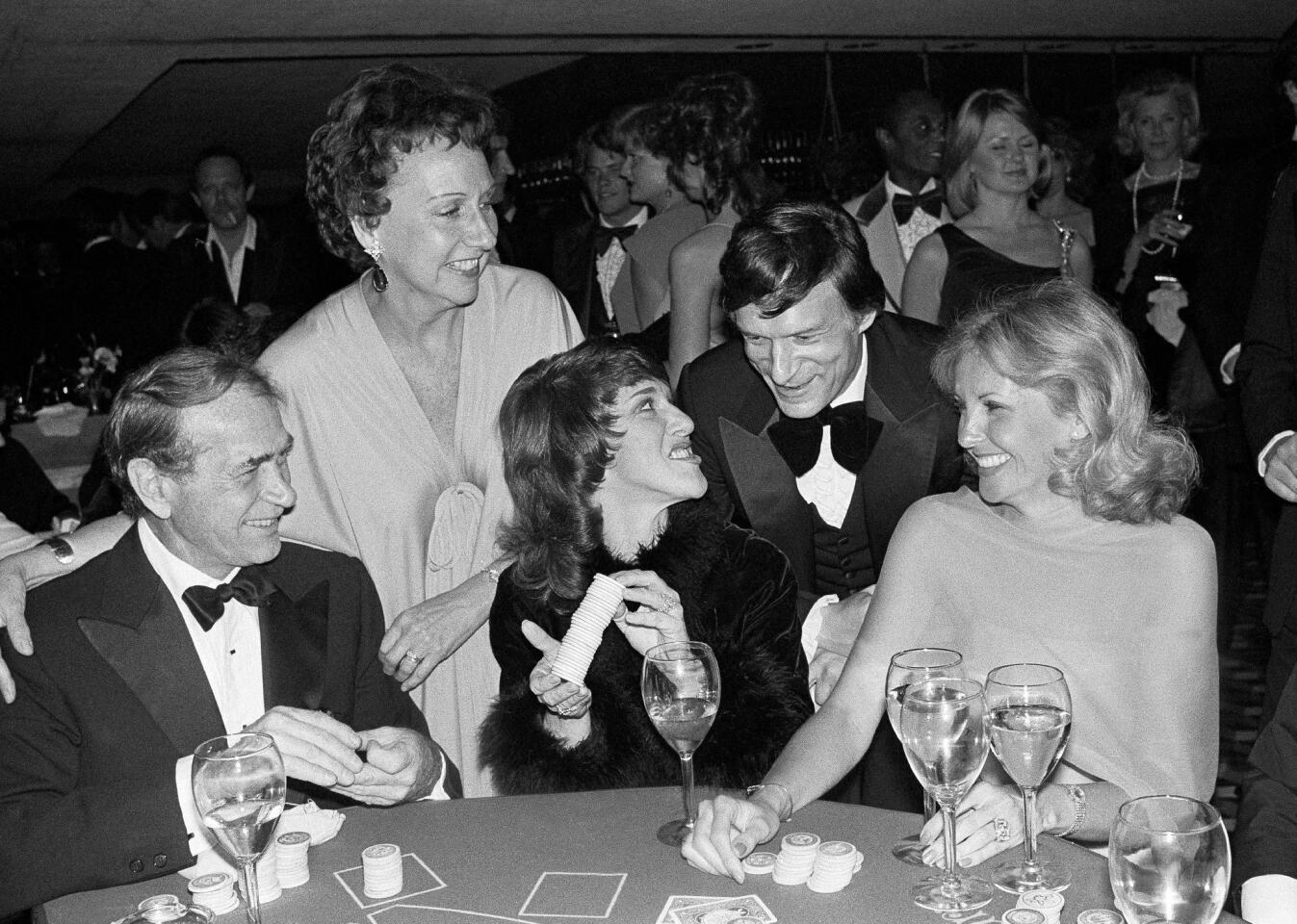 Actress Jean Stapleton, top left, and publisher Hugh Hefner laugh with, from foreground left, Darren McGavin, Ruth Buzzi and Barbara Fisher, during a black-tie casino fundraiser in Los Angeles in 1979.