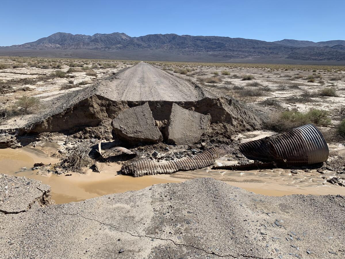 A roadway and culvert with heavy flood damage.
