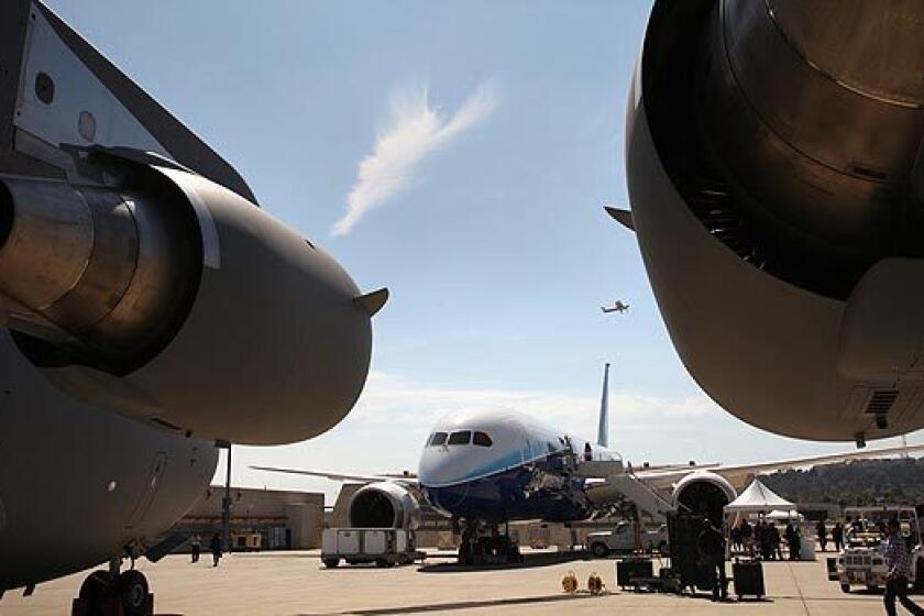 Boeing's 787 Dreamliner is framed between two large engines of a C-17 cargo plane on the tarmac at Boeing's plant in Long Beach. The aircraft maker has taken 870 orders for the Dreamliner, making it one of the biggest-selling planes ever built. See full story