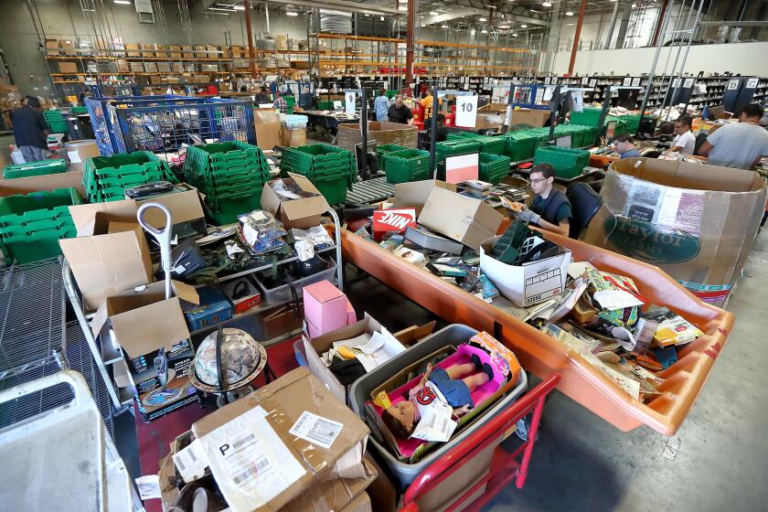 Program participants sort through and categorize donated items at Goodwill Industries Orange County in Santa Ana on Monday, Oct. 16.