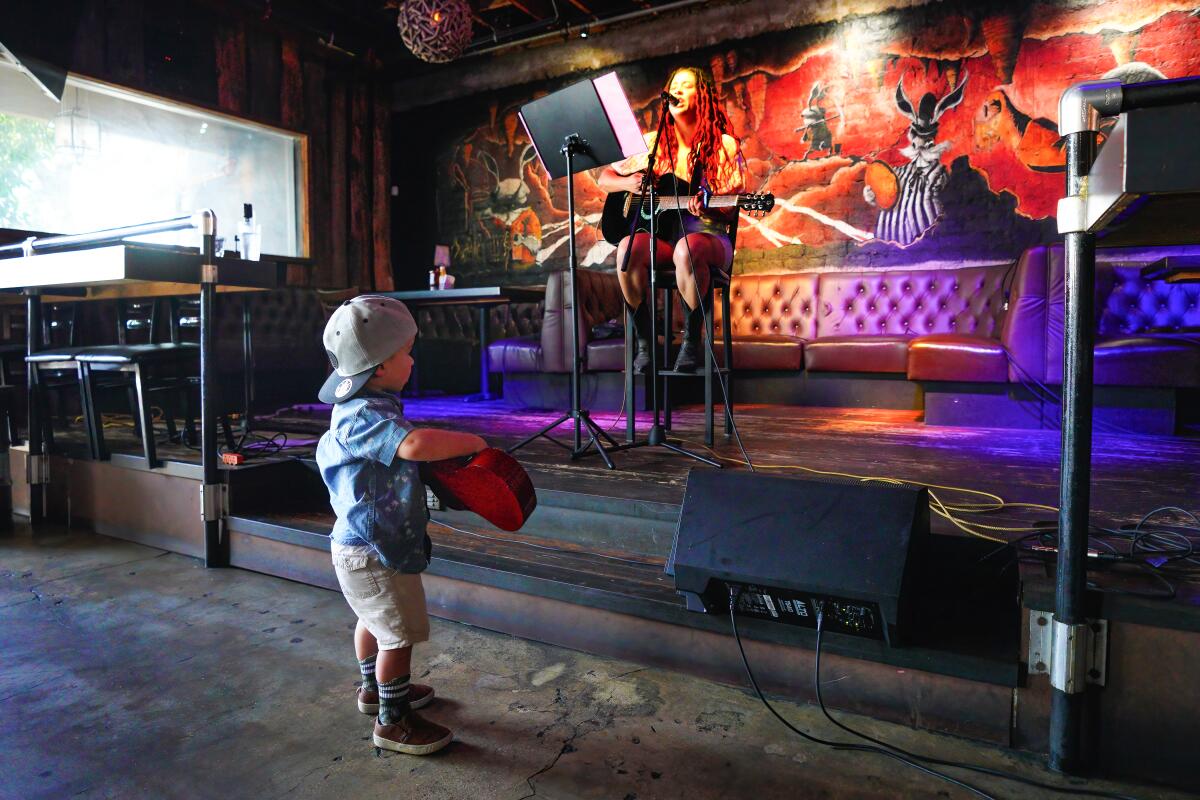 A child watches a singer perform at Adams Avenue Unplugged in 2023.