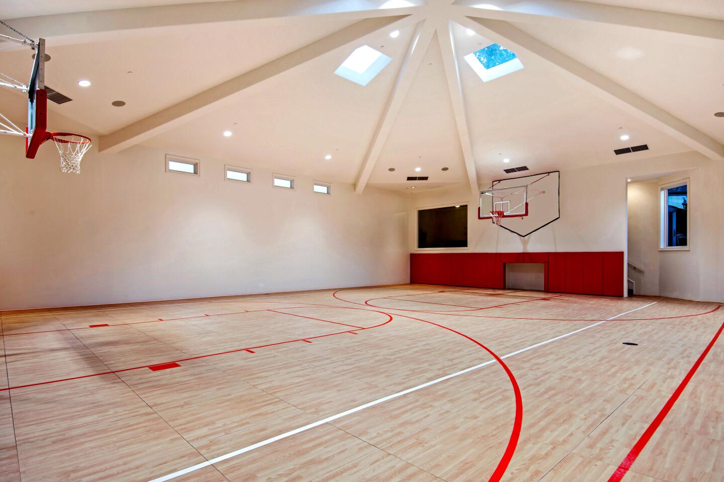The indoor basketball court features a scoreboard, skylights and a viewing box.