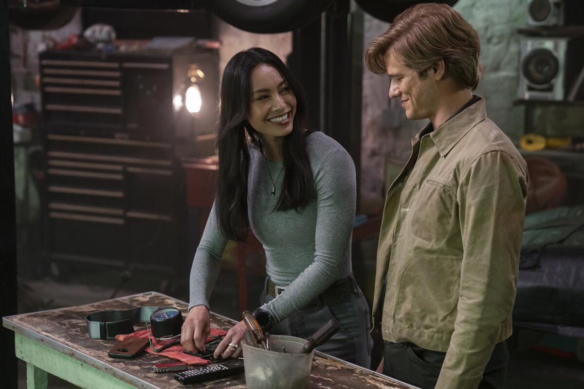 Levy Tran and Lucas Till stand at a workbench in "MacGyver."