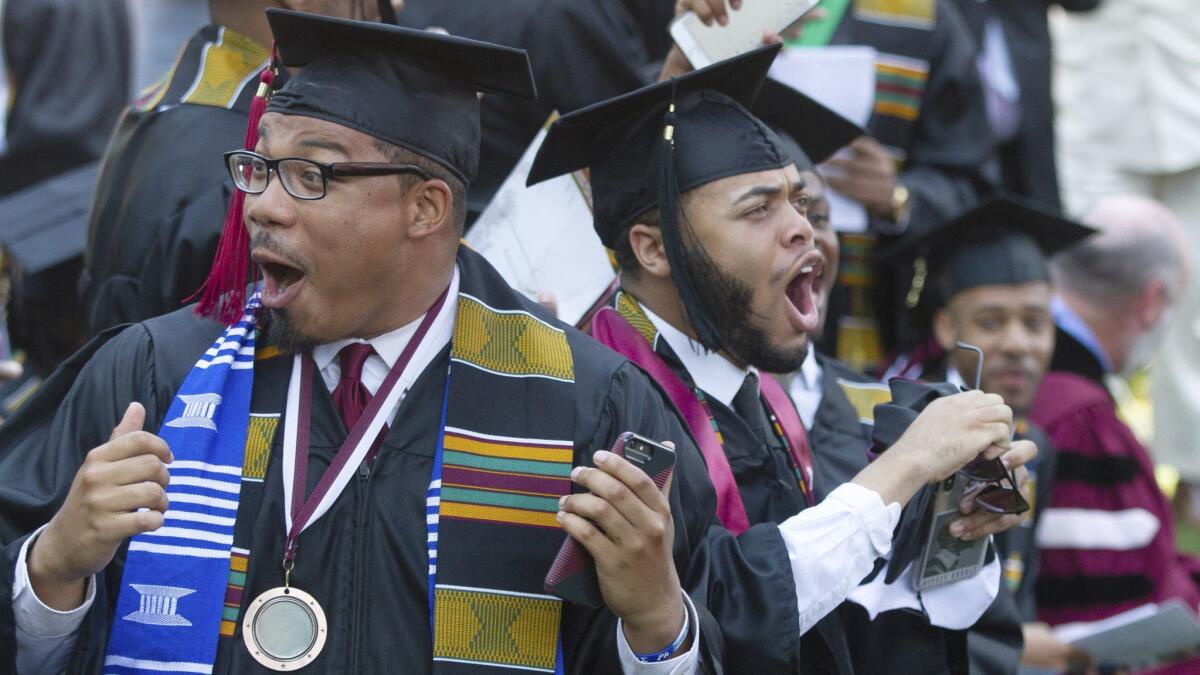 Graduates react after hearing billionaire technology investor and philanthropist Robert F. Smith say he will provide grants to wipe out the student debt of the entire 2019 graduating class at Morehouse College in Atlanta on May 19.