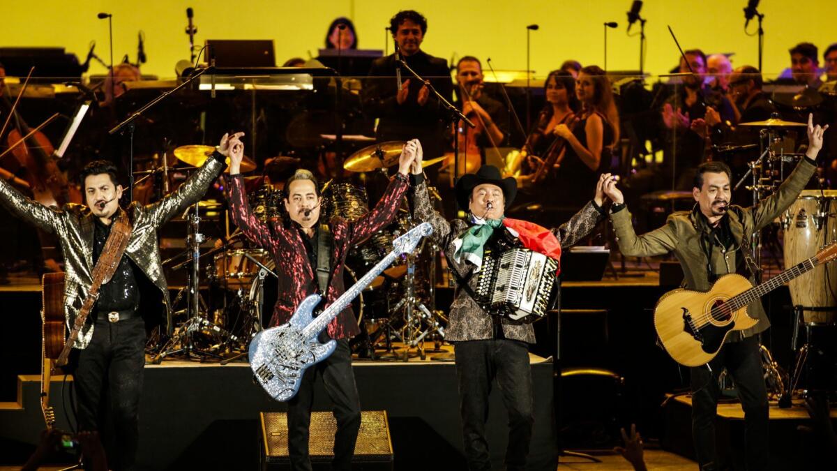 Members of Los Tigres del Norte take a bow before the Youth Orchestra Los Angeles at the Hollywood Bowl.