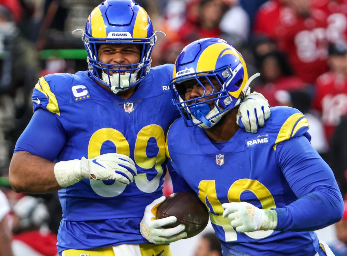 Rams Aaron Donald (99) and Von Miller and celebrate after Miller's strip sack of Buccaneers quarterback Tom Brady.