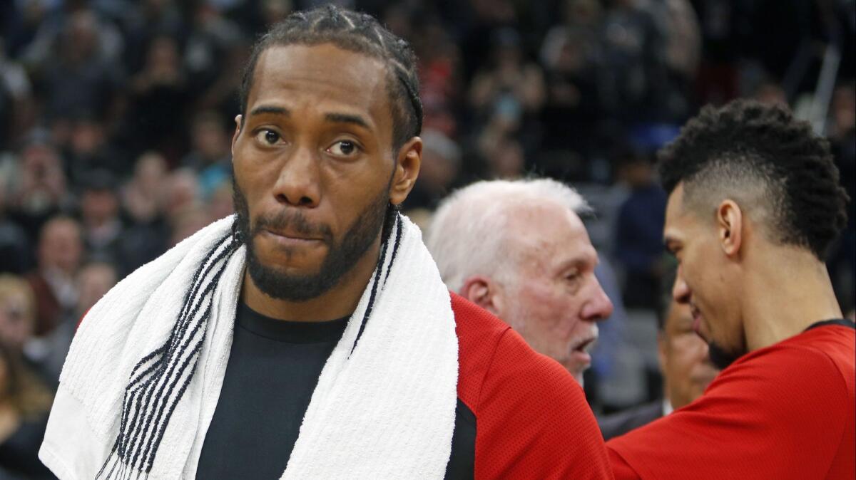 Kawhi Leonard, along with Raptors teammate Danny Green, spoke with their former coach Gregg Popovich (center) after the Jan. 3 game at AT&T Center.