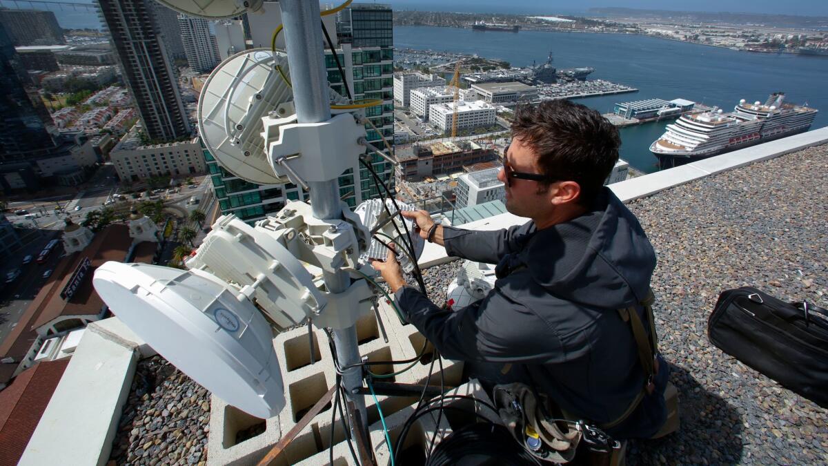 Webpass technician Adam Larnach installs an upgraded millimeter wave radio on the rooftop of a high-rise condo unit in downtown San Diego. The upgraded piece of hardware will increase Internet bandwidth for download and upload.