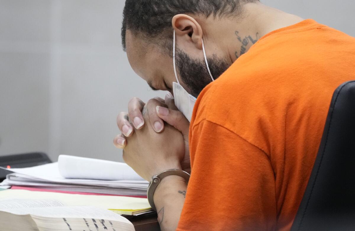 Darrell Brooks puts his head in his hands as Sheri Sparks, mother of 8-year-old Jackson Sparks who was killed in the parade, reads a victim statement during Brooks' sentencing in a Waukesha County Circuit Court in Waukesha, Wis., on Tuesday, Nov. 15, 2022. Dozens of people are expected to speak at the sentencing proceedings for Brooks, who is convicted of killing six people and injuring dozens more when he drove his SUV through a Christmas parade in Waukesha last year. (Mike De Sisti/Milwaukee Journal-Sentinel via AP, Pool)