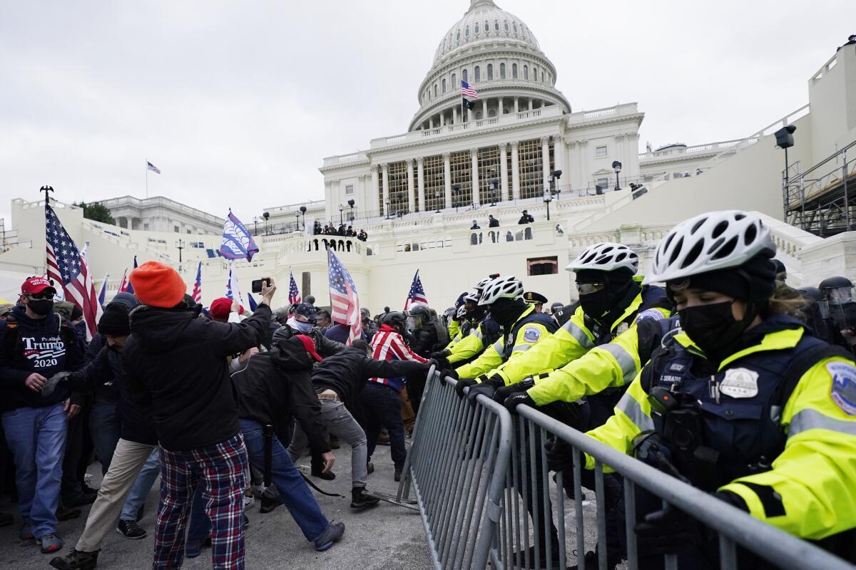 Trump supporters try to break through a police barrier at the Capitol
