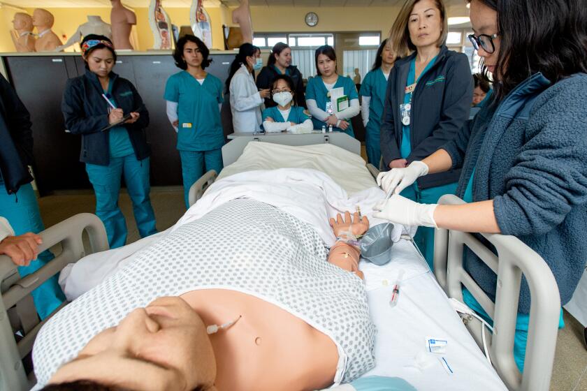 Second-year nursing students practice treatments on a dummy at Golden West College Tuesday, March 7