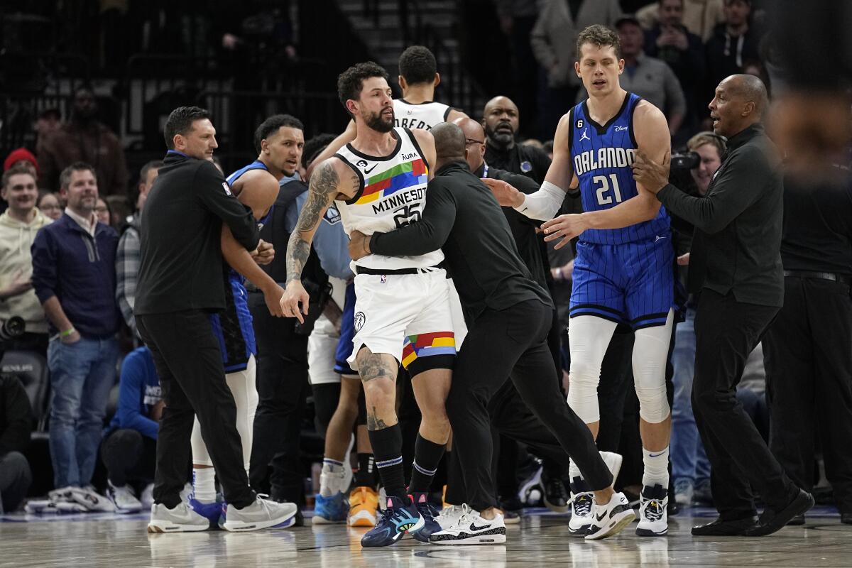 Minnesota Timberwolves guard Austin Rivers, middle, is held back after participating in a scrum with Orlando Magic players during the second half of an NBA basketball game, Friday, Feb. 3, 2023, in Minneapolis. (AP Photo/Abbie Parr)