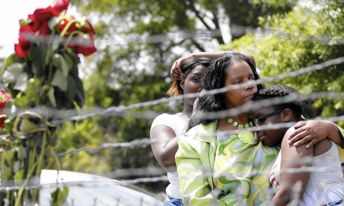 Waynetta Theodore, left, Alberta Harris and Christiena Preston pay their respects on May 10 at a memorial near the site in Hattiesburg, Miss., where two police officers were killed during a traffic stop.