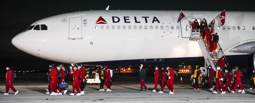 The Alabama team disembarks from a plane Friday, Jan. 7, 2022, at Indianapolis International Airport in Indianapolis. Alabama is scheduled to play Georgia on Monday in the College Football Playoff championship game. (Michelle Pemberton/The Indianapolis Star via AP)