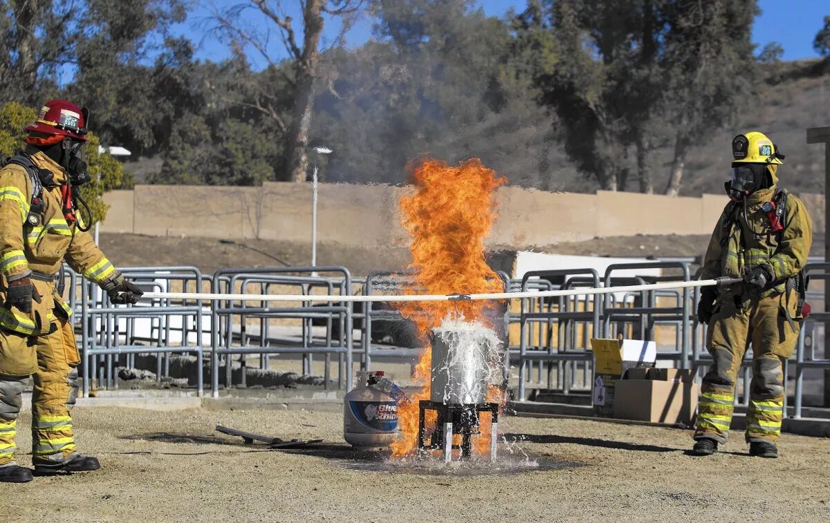 Firefighters fry a turkey in a pot filled with hot cooking oil during a fire safety demonstration.