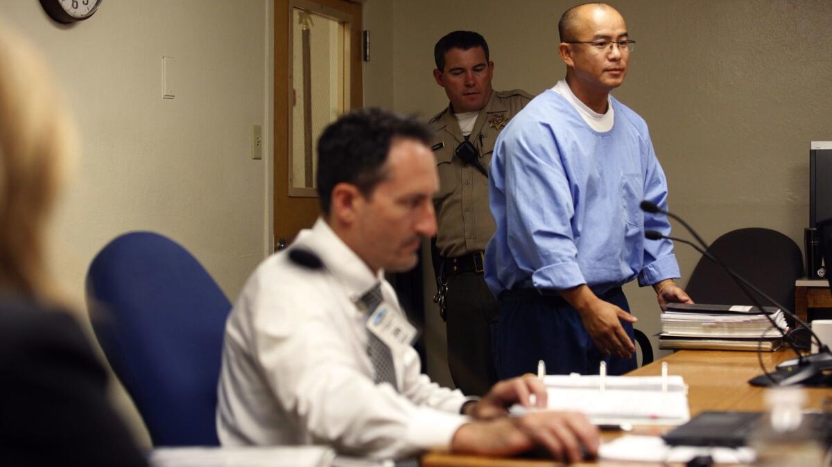 State inmate Kao Saelee, right, arrives for his initial suitability hearing in June before a three-member panel from the California Board of Parole Hearings. (Brian van der Brug / Los Angeles Times)