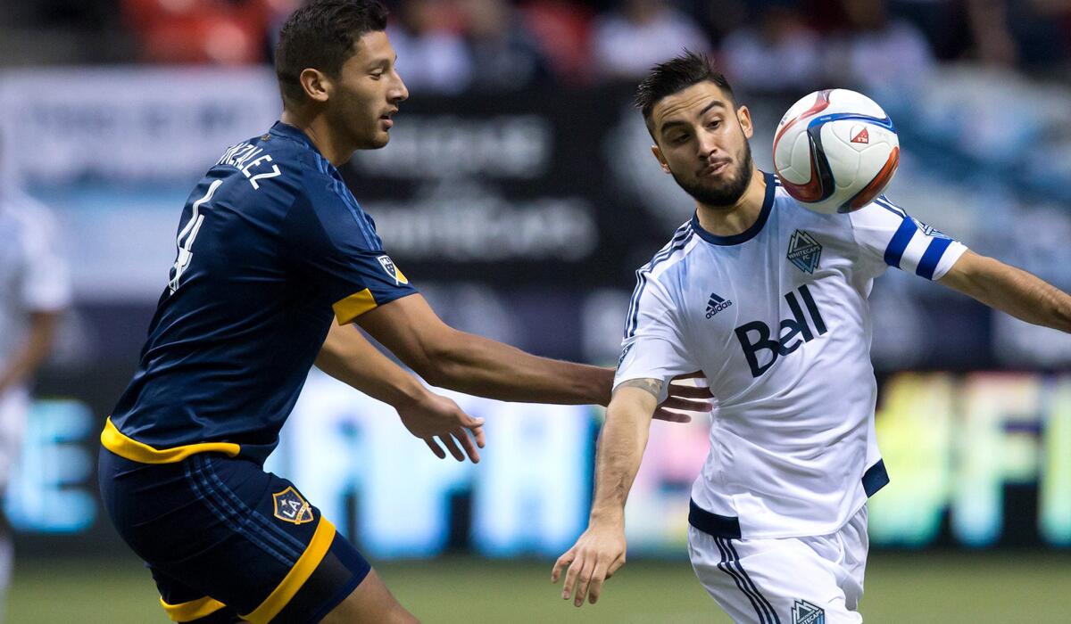 Omar Gonzalez, left, defends against Whitecaps midfielder Pedro Morales during a Galaxy game on April 4 in Vancouver, Canada.