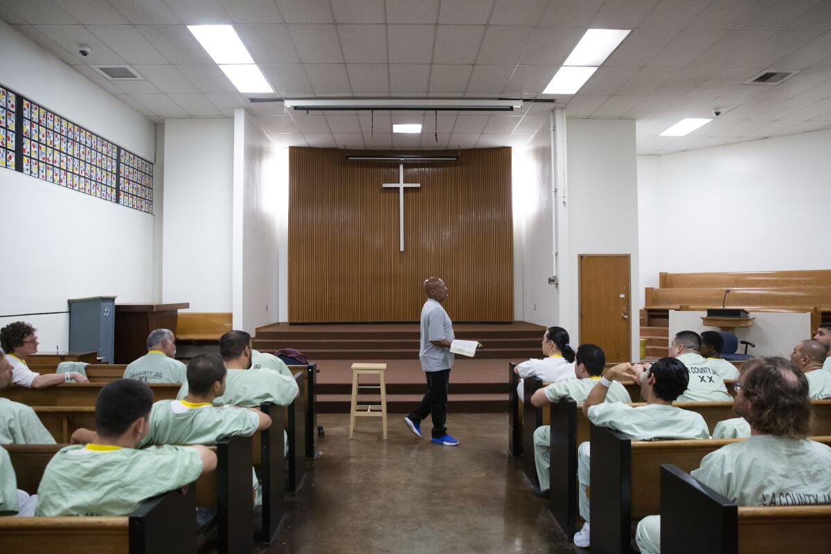 Pastor Titus Cooper preaches at Men's Central Jail. Some Christian faiths in the jail have hundreds of volunteers who meet with inmates one-on-one, teach bible study and hold services.