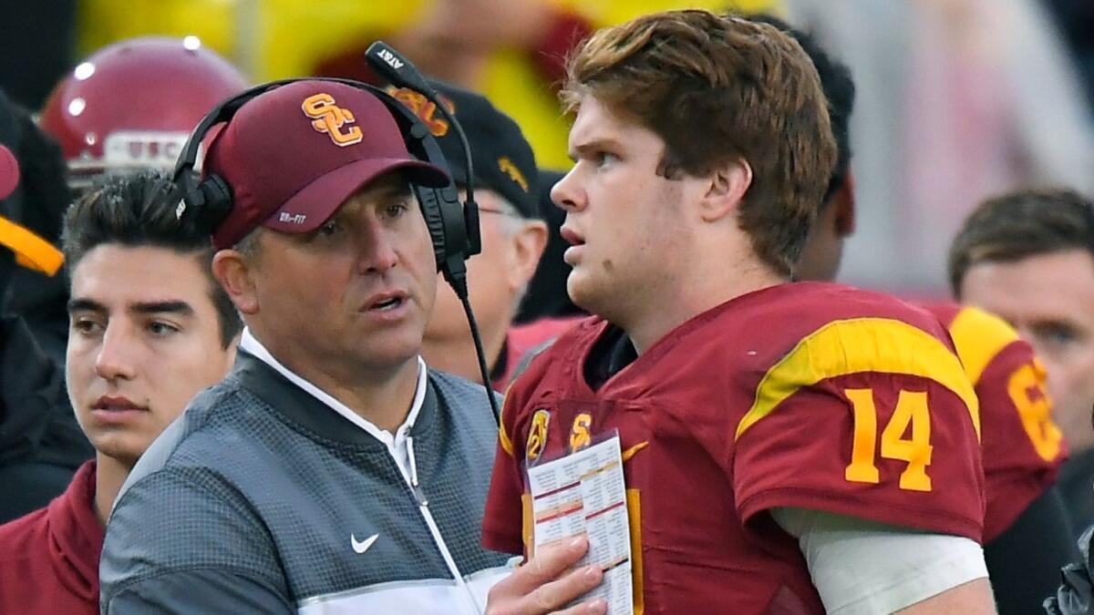 USC Coach Clay Helton, left, talks with quarterback Sam Darnold during the Trojans' game against Notre Dame on Nov. 26.