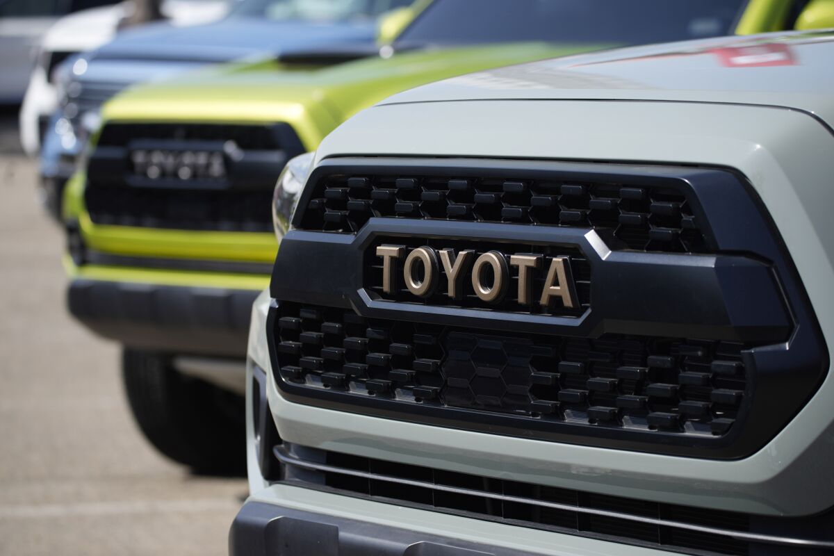 FILE - The company logo highlights the grille of a 2021 Tacoma pickup truck on display in the Toyota exhibit at the Denver auto show Friday, Sept. 17, 2021, at Elitch's Gardens in downtown Denver. Japan’s top automaker Toyota reported Thursday, Nov. 4, 2021, a 33% jump in second fiscal quarter profit, as it raised its full year forecast, despite supply chain woes related to the coronavirus pandemic. (AP Photo/David Zalubowski, File)
