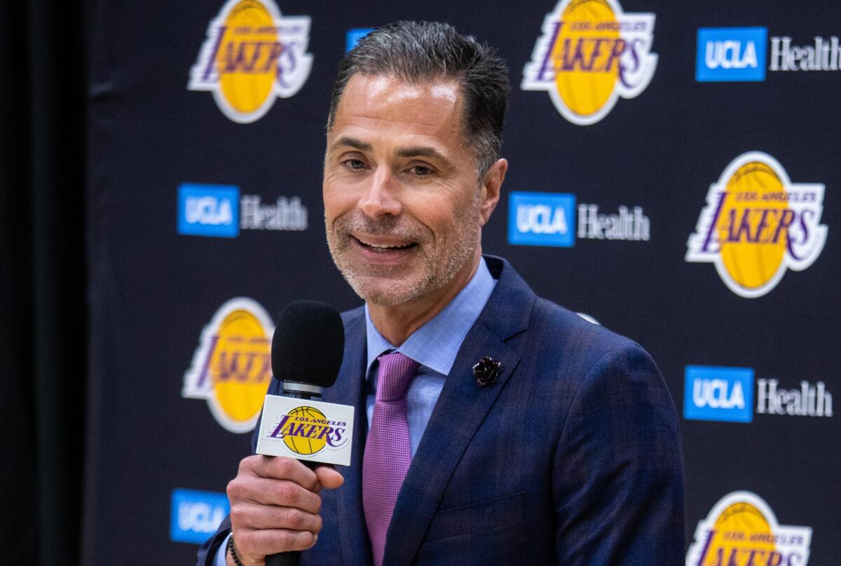 Lakers general manager Rob Pelinka speaks at a news conference as coach Darvin Ham sits nearby.