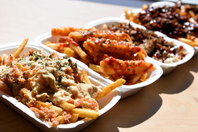 GARDENA, CALIFORNIA FEBRUARY 28, 2017-Lemon garlic snow crab fries, left, along with other choices at Mr. Fries Man in Gardena. (Wally Skalij/Los Angeles Times)