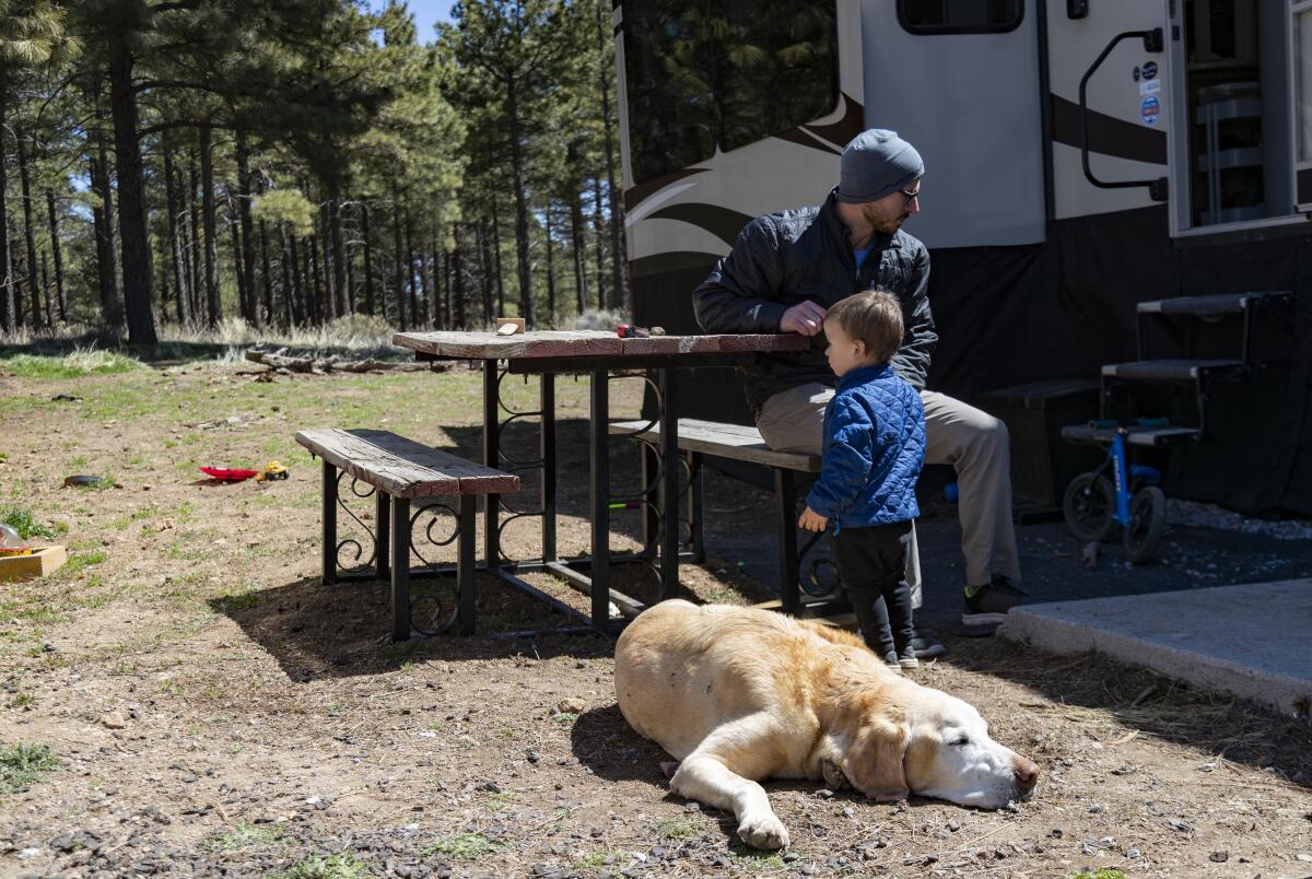 Cody Taylor spends time with his son and dog at Black Bart's RV Park in Flagstaff.