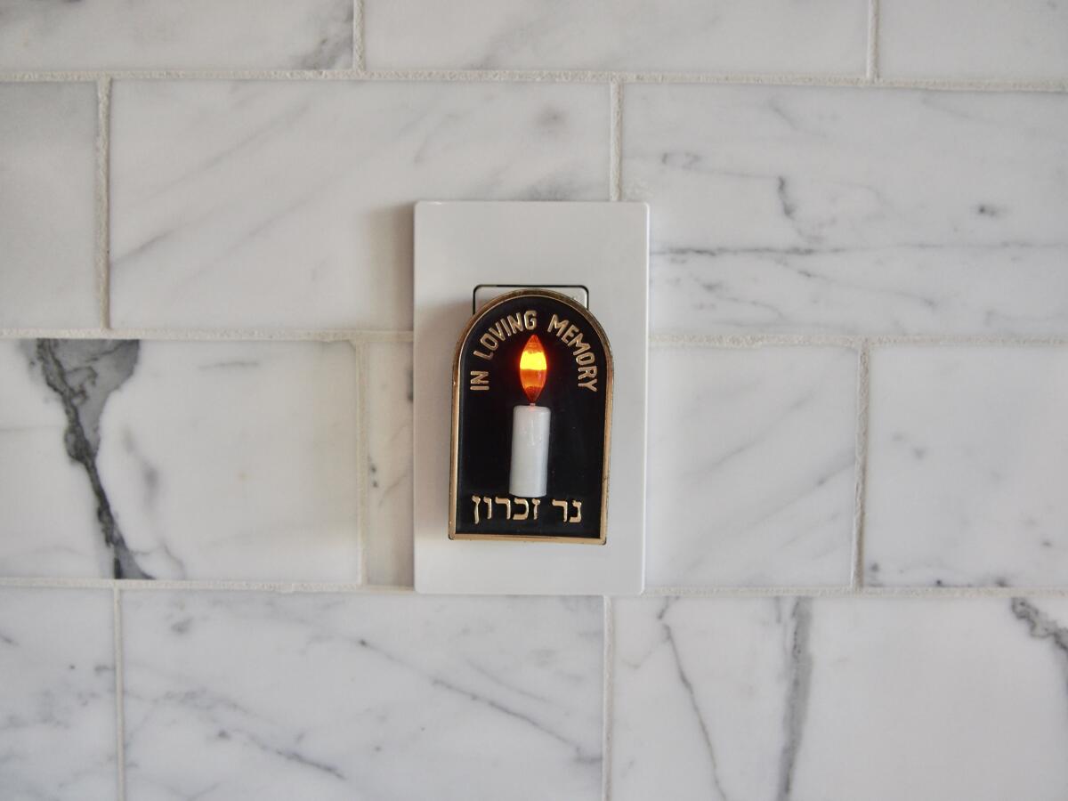 An electric Yahrzeit candle inscribed with the words "In Loving Memory" in English and "Ner Zicaron" in Hebrew.