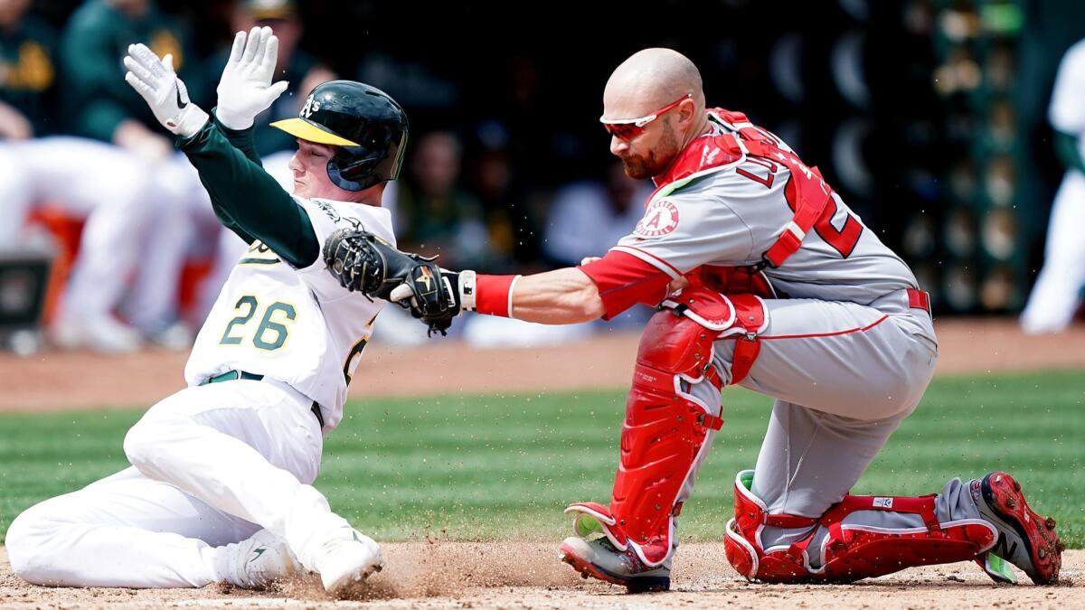 Jonathan Lucroy (20) of the Angels tags out Matt Chapman (26) of the Oakland Athletics at home plate in the bottom of the third inning.