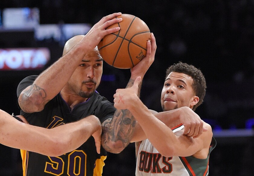 Lakers center Robert Sacre tries to power his way to the basket against Bucks guard Michael Carter-Williams in the first half Friday night at Staples Center.