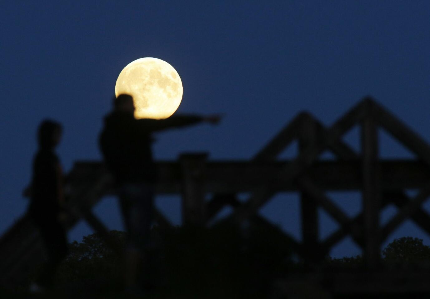 People watch a perigee moon, also known as a super moon, rises in Mir, Belarus, 95 kilometers (60 miles) west of capital Minsk, Belarus.