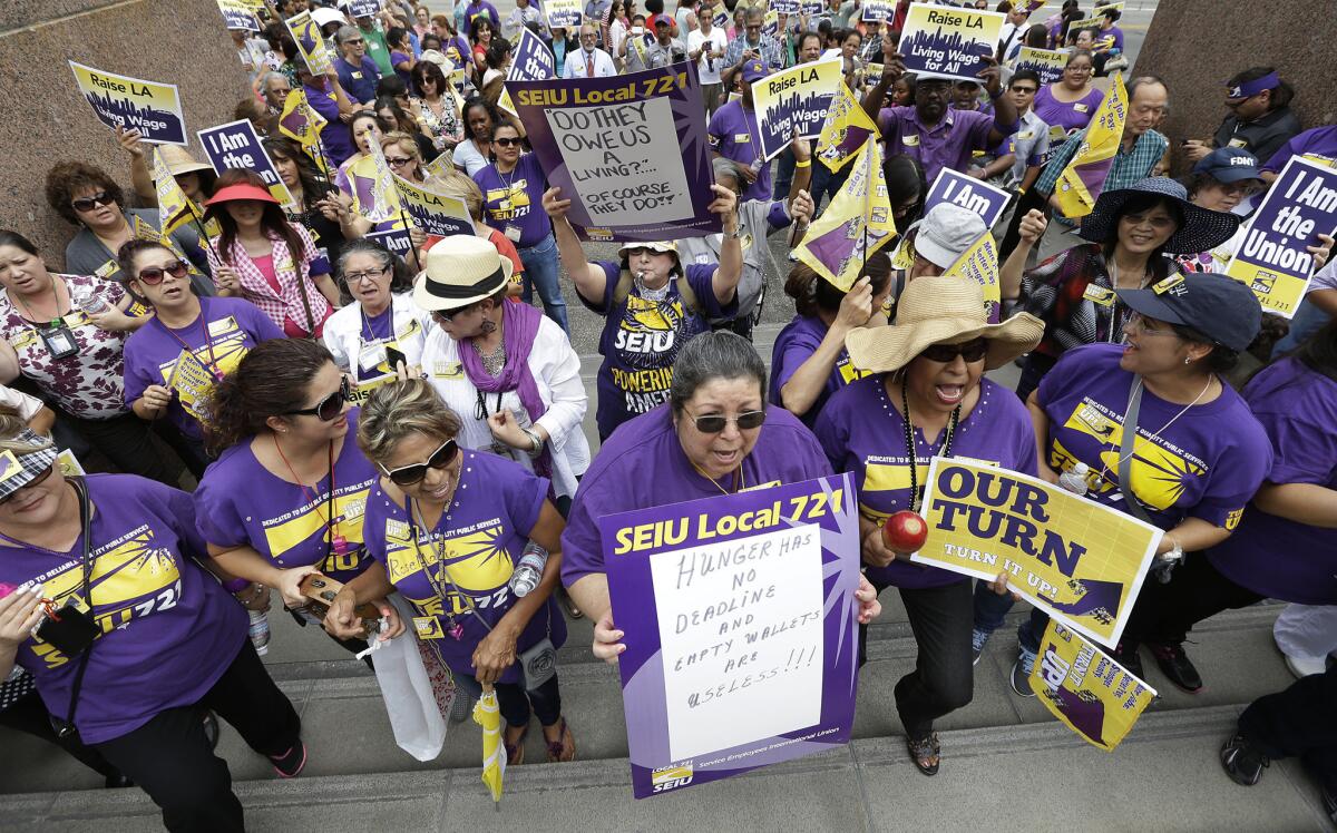 Scores of people who work for businesses that contract with L.A. County demonstrate for an increase in the living wage outside Tuesday's Board of Supervisors' meeting in downtown L.A.