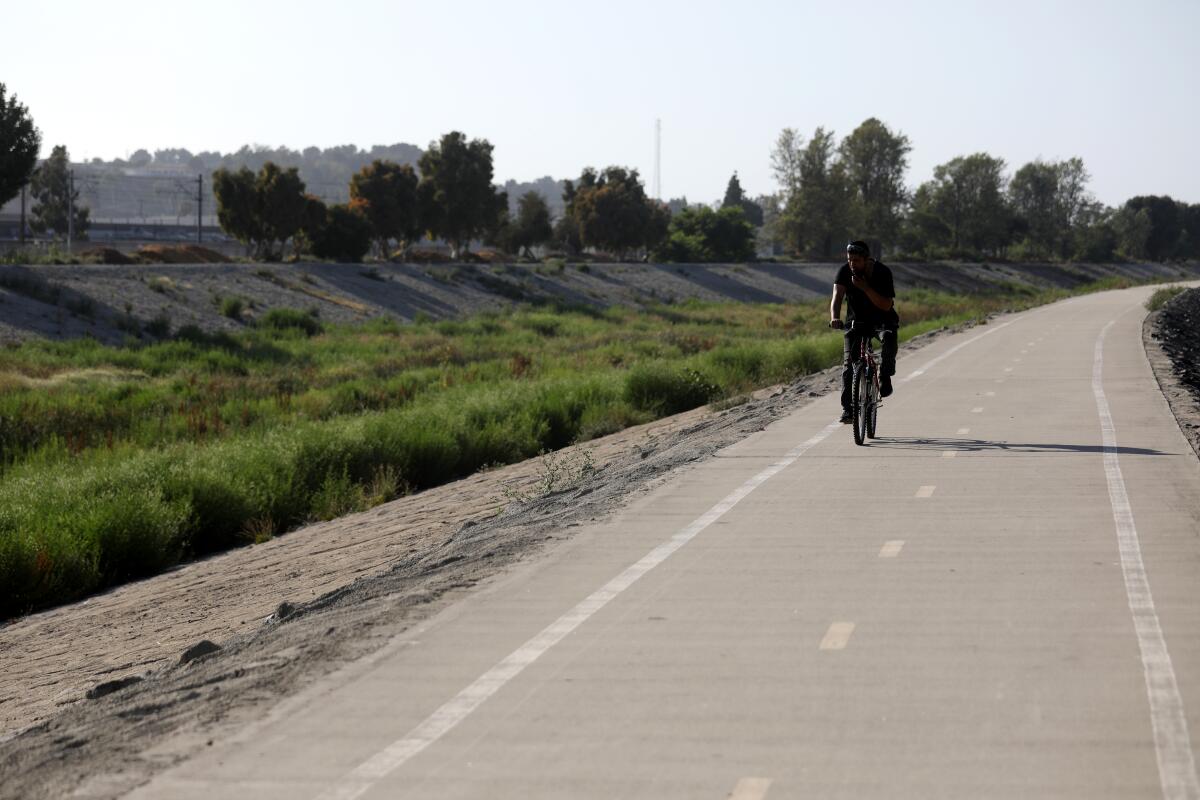 A bicyclist rides alone on a bike path.