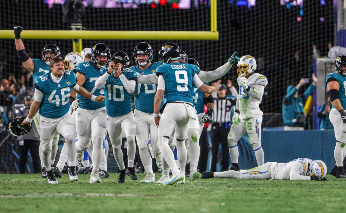 Jaguars celebrate as Charger Amen Ogbongbemiga lies face-down on the ground.