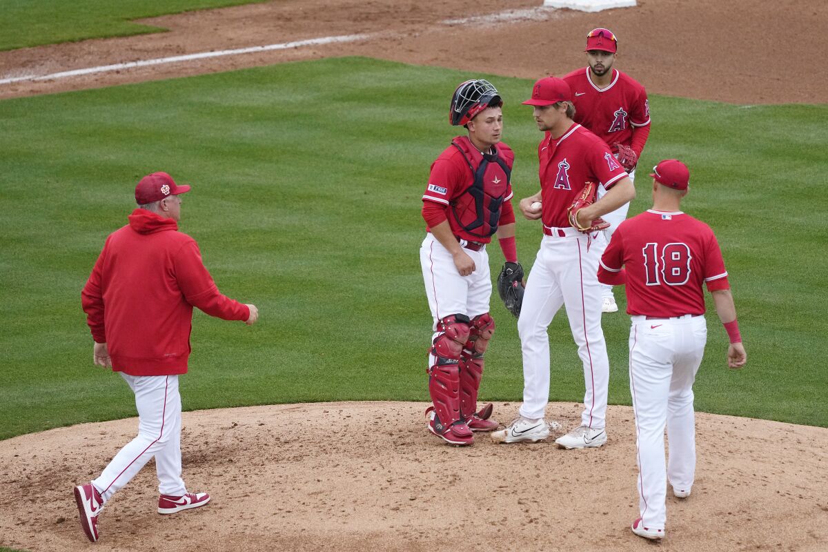 Angels pitcher Ben Joyce speaks to teammates as Angels manager Phil Nevin, left, arrives at the mound.